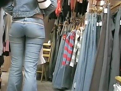 The delicious girl in tight jeans is in the store choosing a new pair of the hot pants free nude pictures